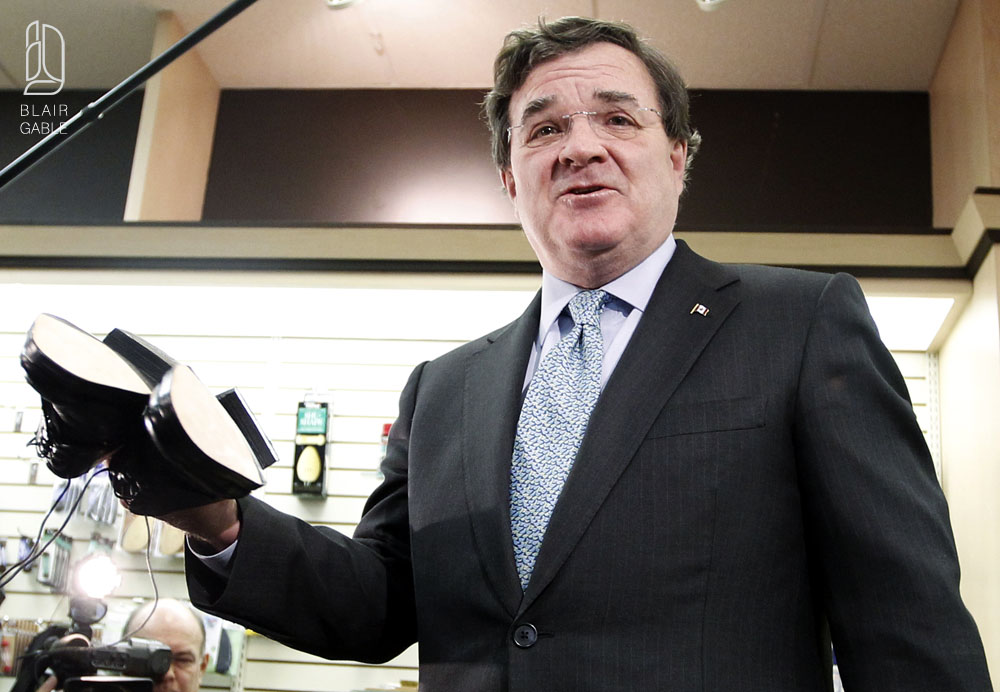 Canada's Finance Minister Flaherty holds up his 'budget' shoes after having them resoled in Ottawa