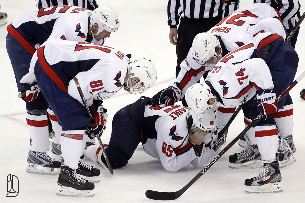 Washington Capitals' surround Perreault after he's hit by the puck